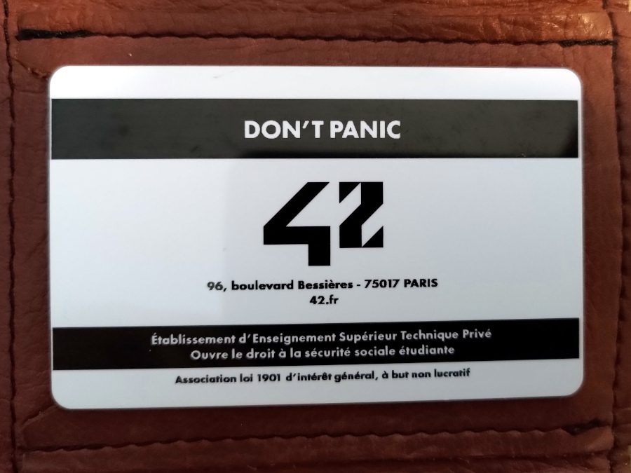Badge d'accès à l'école 42 à Paris. Chaque étudiant et chaque candidat à la piscine en reçoit un. Au dos est inscrit le message, don't panic.